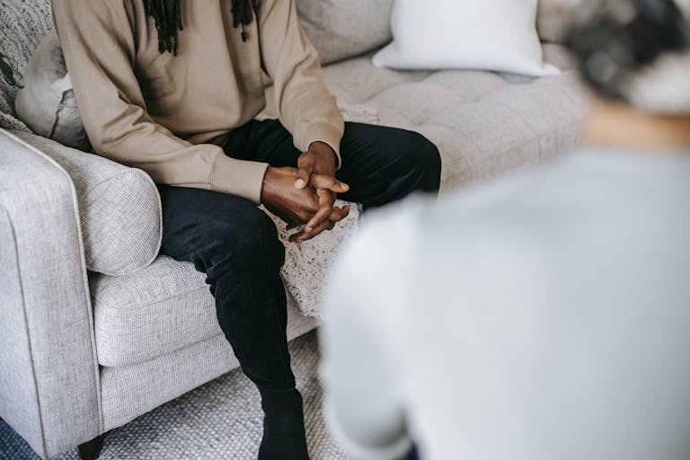 Homme assis sur un canapé lors d'une consultation avec une thérapeute en relation d'aide